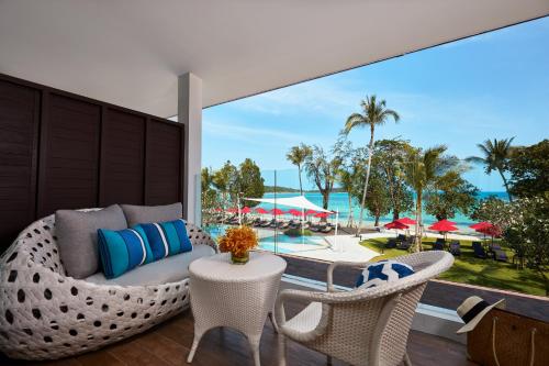 a patio with a couch and chairs and a view of a pool at Amari Koh Samui in Chaweng