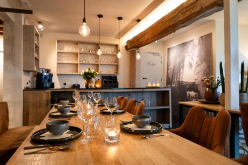 Un comedor con una larga mesa de madera y sillas. en B&B Langeveldemolen, en Merchtem