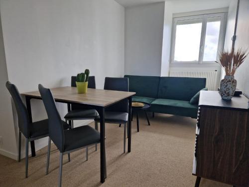 a living room with a table and chairs and a couch at Proche rocade sud in Rennes