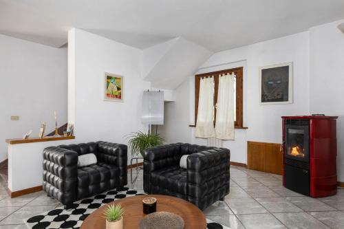 a living room with two chairs and a fireplace at Villa Luisa Design in Colle Val D'Elsa
