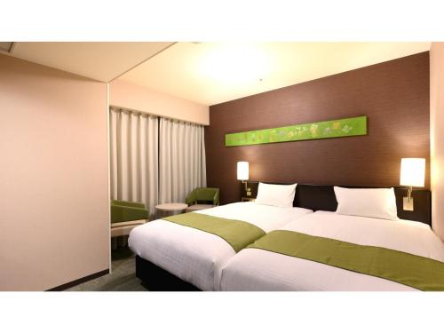 une chambre d'hôtel avec un grand lit dans une chambre dans l'établissement Smile Hotel Premium Kanazawa Higashiguchi Ekimae - Vacation STAY 73598v, à Housai