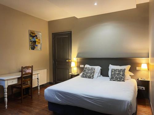 a bedroom with a bed and a desk and a table at T2 élégant & confortable, balcon - Amiens centre in La Celle-sous-Gouzon