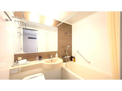 une salle de bain avec un lavabo et un miroir dans l'établissement Smile Hotel Premium Kanazawa Higashiguchi Ekimae - Vacation STAY 73601v, à Housai