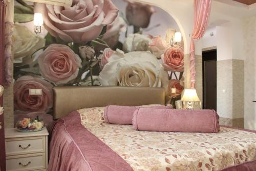 ヴォロネジにあるApartment on Karla Marksa 116 A (9-etaz)のベッドルーム1室(バラの絵画が飾られたベッド1台付)