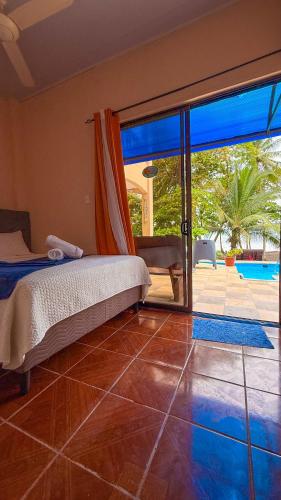 a bedroom with a bed and a view of a pool at Hotel Beachfront Vista Hermosa in Jacó