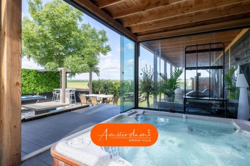 an indoor hot tub in a house with a patio at Amsterdam Group Villa 20 plus beds 4 - 5 bedrooms in Zwanenburg