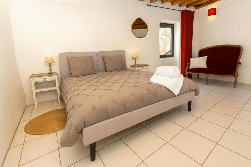 ein großes Bett in einem Zimmer mit einem Stuhl und einem Tisch in der Unterkunft Collias Bord du Gardon, near Uzès and Pont du Gard in Collias