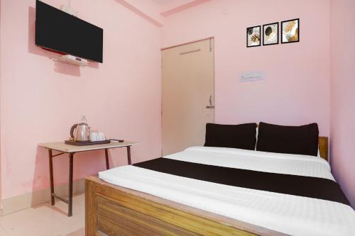 um quarto com uma cama e uma TV na parede em Hotel O Danapur Central Railway Junction Formerly Brij Guest House em Patna
