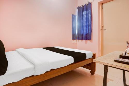 um quarto com uma cama e uma cortina azul em Hotel O Danapur Central Railway Junction Formerly Brij Guest House em Patna