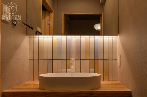 ein Badezimmer mit einem weißen Waschbecken und einem Spiegel in der Unterkunft Kyoran [Yugosuma Residence] - Vacation STAY 69017v in Kyōto