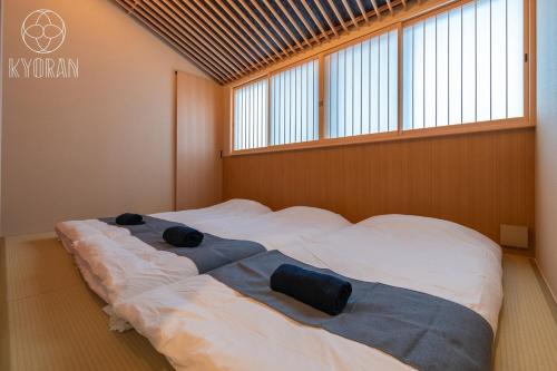un grand lit dans une chambre avec une grande fenêtre dans l'établissement Kyoran [Gensui Residence] - Vacation STAY 69054v, à Kyōto