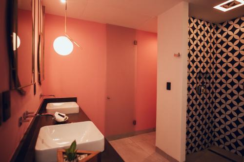 a bathroom with orange walls and a sink at CALIXTA Hotel in Playa del Carmen