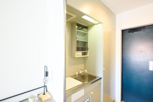 een badkamer met een wastafel en een spiegel bij Hotel Stripe Sapporo - Vacation STAY 20488 in Kita-rokujō