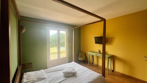een slaapkamer met een bed, een raam en een bureau bij Maison de standing avec vue à couper le souffle ! in Molles