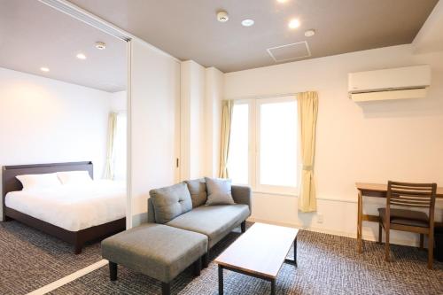 a hotel room with a bed and a couch at Hotel Stripe Sapporo - Vacation STAY 20494 in Kita-rokujō