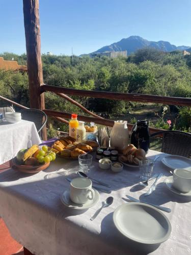 a table with a breakfast of food and coffee on it at Cabañas Taos Pueblo in Capilla del Monte