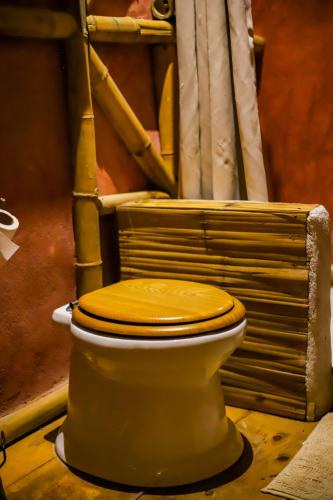 a toilet with a wooden seat in a room at Casa Lorette in Martínez