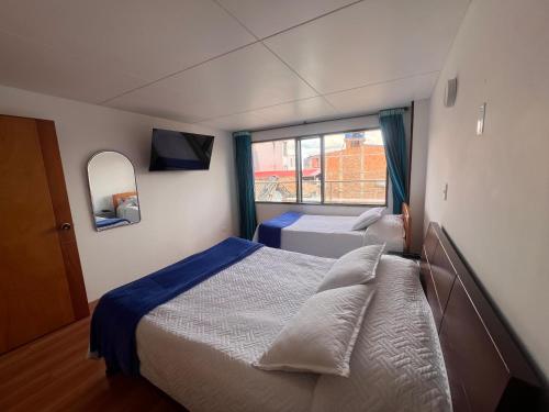 a bedroom with two beds and a window at El Gran Hotel in Chiquinquirá