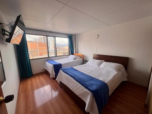 a bedroom with two beds and a window at El Gran Hotel in Chiquinquirá