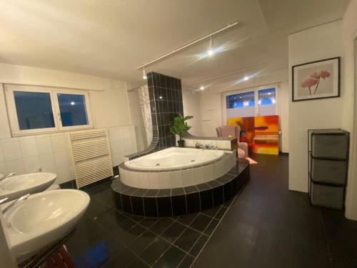 a large bathroom with a tub and two sinks at Stay Inn - Meisterschwanden in Meisterschwanden