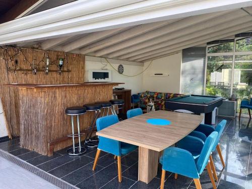 a restaurant with a wooden table and blue chairs at Stay Inn - Meisterschwanden in Meisterschwanden