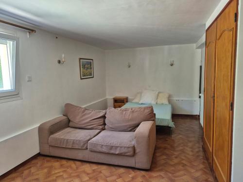 ein Wohnzimmer mit Sofa und Bett in der Unterkunft Charmant studio centre village in Gréoux-les-Bains