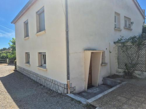 ein weißes Haus mit einer Seitentür in der Unterkunft Charmant studio centre village in Gréoux-les-Bains