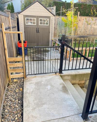 a gate in a fence with a driveway at Excellent Place to Stay in Coquitlam