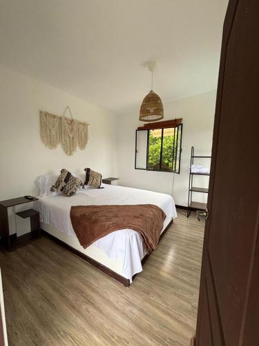 a bedroom with a large white bed and a window at Wakana Ecosuits in Apulo
