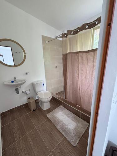 a bathroom with a toilet and a sink and a shower at Wakana Ecosuits in Apulo