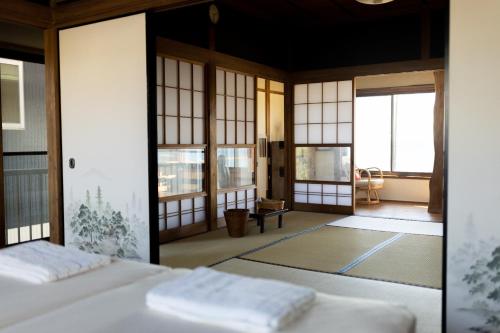 a room with a bed and a room with windows at Haraoka House - Vacation STAY 74364v in Haraoka
