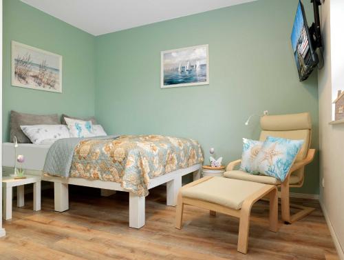 a small bedroom with a bed and a chair at Glück Ahoi in Insel Poel