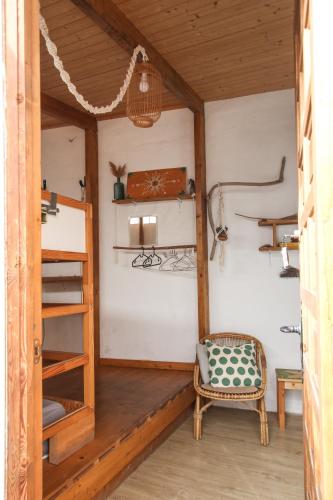 a room with a ladder and a chair and shelves at Casa Calma Yoga Hostel in Agaete