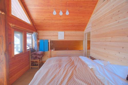 une chambre avec un lit dans une cabane en bois dans l'établissement Nagano - Cottage - Vacation STAY 75905v, à Chūsha