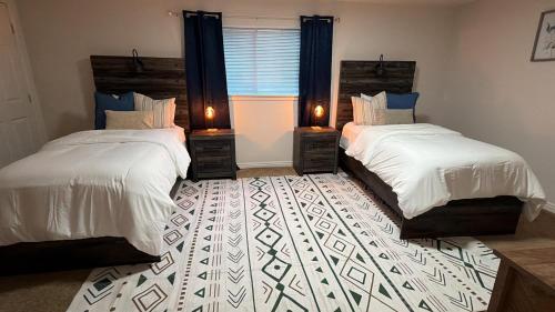 a bedroom with two beds and a window with two lamps at Cozy and well located 2-bedroom basement in Provo