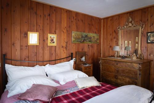 a bedroom with a bed with wooden walls and a mirror at Residenza Le Fontane in Ceppo Morelli