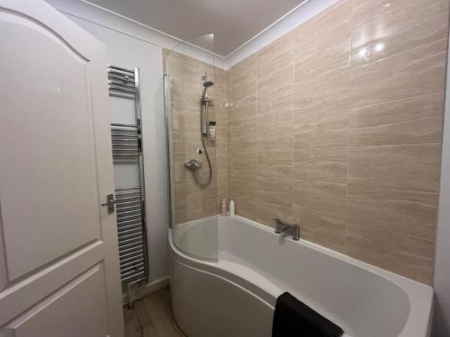 un baño con bañera y ducha en Bungalow on Dartmoor's Edge, Parking & Garden, en Ashburton