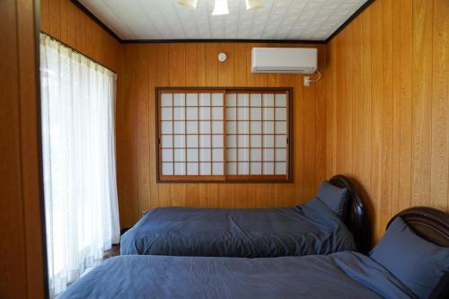 ein Schlafzimmer mit zwei Betten und einem Fenster in der Unterkunft LYS AIBA House - Japanese Garden Villa - Vacation STAY 79096v in Aiba