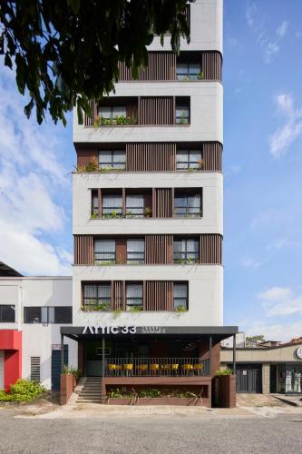 Un edificio alto y blanco con un cartel. en Hotel Attic 33, en Medellín
