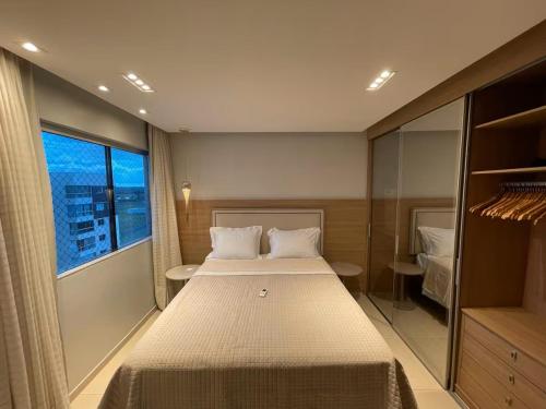 a bedroom with a large bed and a large window at Impecável Cobertura em Paraíso in Luis Eduardo Magalhaes