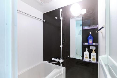 ein Badezimmer mit Badewanne, Waschbecken und Spiegel in der Unterkunft Fontaine Kamata - Vacation STAY 79350v in Tokio