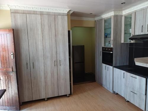 une cuisine avec des placards en bois et une cuisine avec un poêle dans l'établissement Sweet Home Guest House, à East London