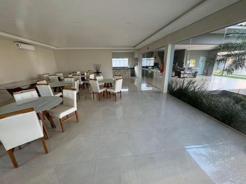 a dining room with tables and chairs and a cafeteria at Impecável Cobertura em Paraíso in Luis Eduardo Magalhaes