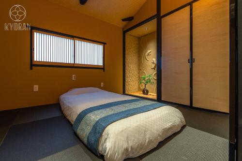 ein Schlafzimmer mit großem Bett und Fenster in der Unterkunft "Jinglan-Purple Bamboo Residence" - Vacation STAY 80054v in Kyōto