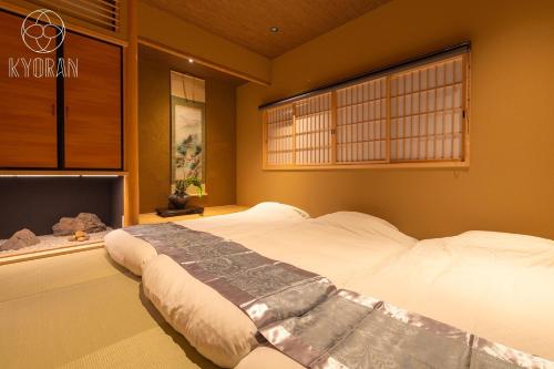 ein Schlafzimmer mit einem großen weißen Bett mit einem Fenster in der Unterkunft Kyoran [Phantom Flower Residence] - Vacation STAY 80036v in Kyōto