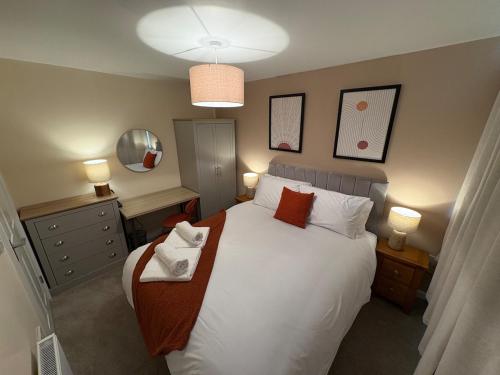 ein Schlafzimmer mit einem Bett mit weißen Laken und Kissen in der Unterkunft Greenfield House - Keighley Eastburn in Kildwick