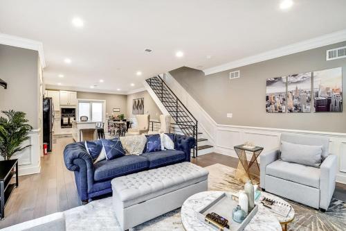 a living room with a blue couch and a staircase at Exceptional Downtown Townhome with Roof Deck -4Bedroom & 3Baths in Philadelphia