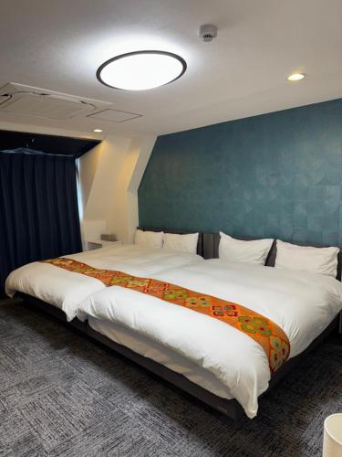 a large bed in a room with a blue wall at Shiba inn in Tokyo