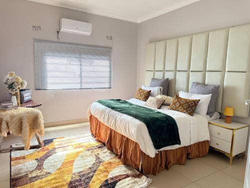 een slaapkamer met een groot bed en een raam bij Spacious Modern 3-Bedroom Foxdale in Foxdale Estates