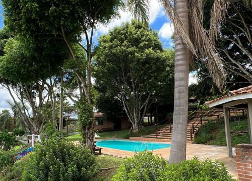 a swimming pool in a yard with trees at Fazenda do Sonhos - Cotia in Cotia